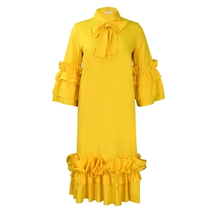 Detail view of the yellow dress showing the tiered ruffle sleeves and chic bow neckline