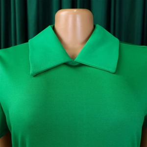 Gros plan du col polo en maille vert vif avec coutures détaillées et texture douce