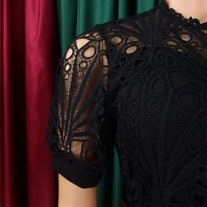 Close-up of black lace patchwork detail featuring intricate hollow fan patterns