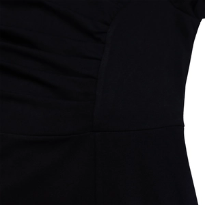 Detailed macro view of black V-neck dress fabric showing ruched texture and fine stitching