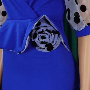 Detail of royal blue dress featuring 3D polka dot flower and ruffle waist design