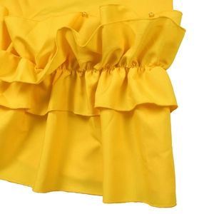 Detail of yellow dress featuring double-layered ruffle hem with matching pearl beads