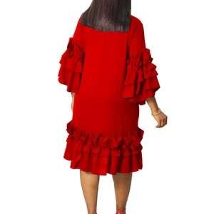 Detailed view of layered ruffle cuffs and hem on a loose red summer dress