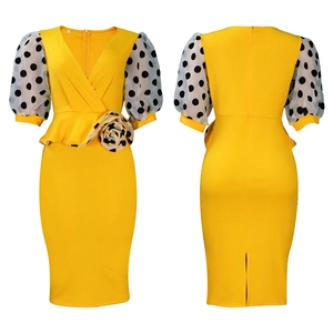 Detail of yellow pencil dress with polka dot puff sleeves and peplum waist flower