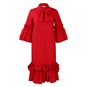 Detail of red long sleeve dress with ruffle hem and bow tie neckline design