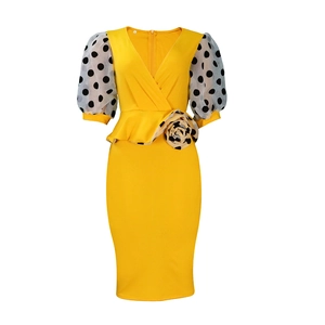 Detail of yellow pencil dress with polka dot puff sleeves and peplum waist flower