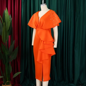 Detail van oranje jurk met V-hals, voorzien van ruches op de schouders en parelversiering