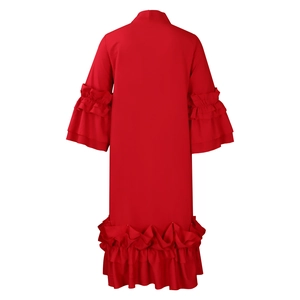 Detail of red dress featuring elegant tiered ruffle sleeves and a wide pleated hemline