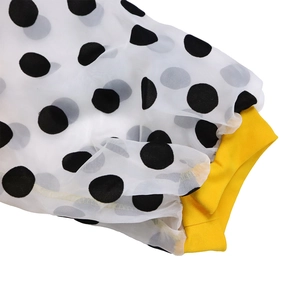 Detail of white mesh bubble sleeve with black polka dots and yellow ribbed cuff