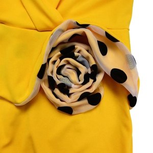 Detail of yellow mesh bubble sleeve with black polka dots and 3D floral accent