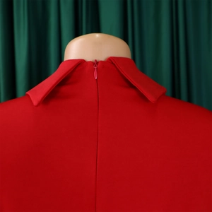 Détail d'une robe de soirée rouge montrant le col à revers et le zip invisible au dos