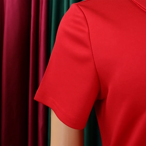 Détail de la couture d'épaule d'un haut rouge à manches courtes et texture du tissu