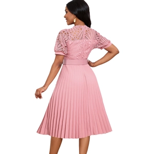 Detail of pink lace bodice with intricate hollow patterns and pleated skirt texture