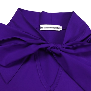 Macro detail of the deep purple V-neckline with a large decorative bow and fine fabric texture