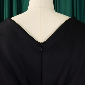 Detail van de onzichtbare ritssluiting op de rug van een elegante zwarte avondjurk