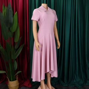 Détail de la robe longue rose à manches courtes avec col chemise et ourlet ondulé étagé