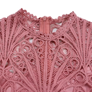 Detail of pink lace dress showing delicate hollow floral patterns and hidden back zipper