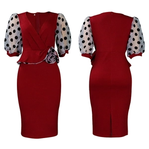 Detail of wine red pencil dress featuring polka dot mesh puff sleeves and waist flower