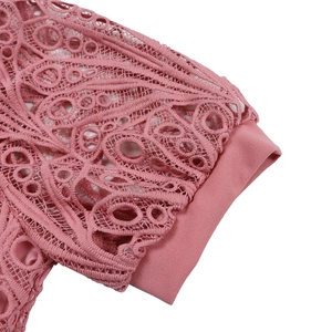 Detailed close-up of pink crochet lace patterns and delicate hem stitching on a dress