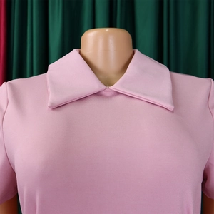 Détail de la maille rose douce et du col à revers sur la robe élégante