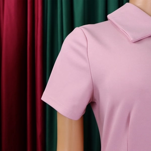 Détails de la robe polo rose à manches courtes avec texture en maille fine et coutures