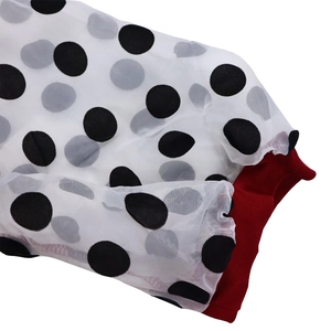 Detailed view of white polka dot tulle sleeves with red elastic cuffs for women's dress