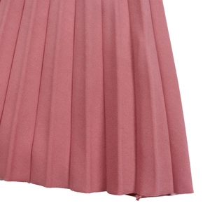 Macro detail of vertical pleats on a dusty rose pink lace chiffon party dress fabric