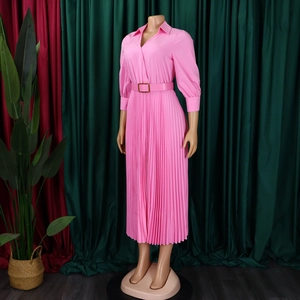 Detail of pink pleated dress featuring a shirt collar V-neckline and elegant waist belt