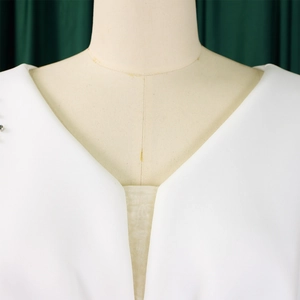 Detail van elegante witte avondjurk met V-hals en glad geweven stof op een paspop mannequin