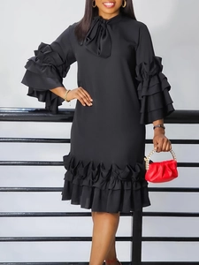 Elegant black long sleeve dress with ruffle sleeves and a bow neckline detail