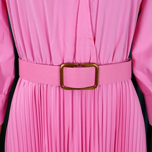 Detail of pink pleated dress featuring a matching waist belt and gold square buckle