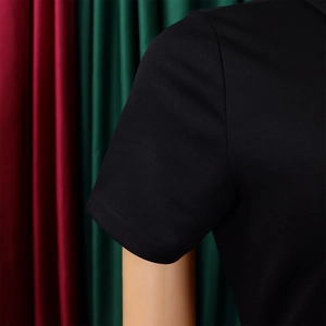 Détail macro du revers de manche courte sur une robe de soirée noire en maille pour femme