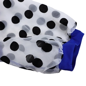 Detail of sheer puff sleeve with black polka dots and blue elastic cuff on pencil dress