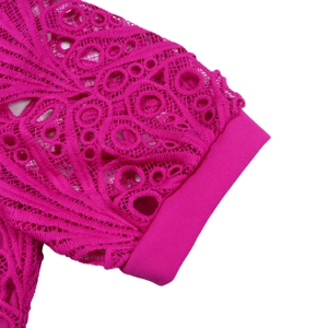 Close-up of fuchsia lace stitching and geometric crochet texture on a women's dress