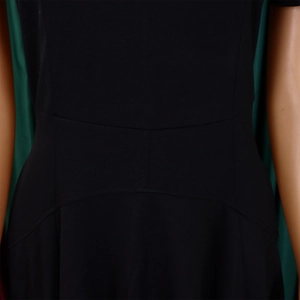 Détail des coutures et de la coupe élégante en U à la taille haute de cette robe noire