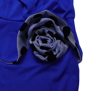 Detail of 3D organza flower with black polka dots on a royal blue dress fabric