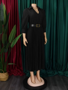 Detail of black pleated maxi dress with elegant lapel collar and gold buckle leather belt