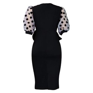 Detail view of the elegant V-neck dress featuring mesh polka dot puff sleeves and back slit