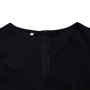 Close-up of V-neckline with invisible back zipper and size M label on black dress