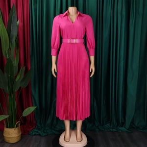 Detail of fuchsia pleated dress showing the shirt collar and waist belt with golden buckle