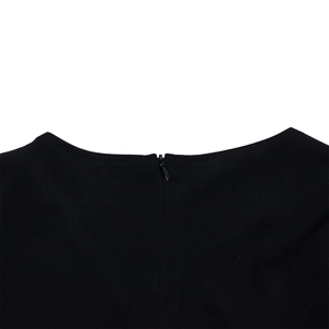 Close-up of invisible zipper and round neckline on a black polka dot pencil dress
