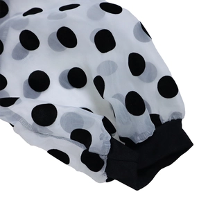 Detail of sheer white tulle puff sleeves with black polka dots and elastic cuffs