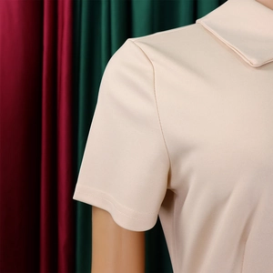 Détail des manches courtes et de la texture du tissu d'une robe polo beige