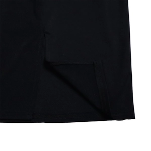 Détail d'une robe noire élégante montrant la fente latérale et la couture d'ourlet
