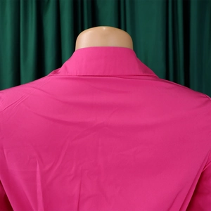 Detailed back view of the stylish lapel collar on a vibrant rose pink pleated dress