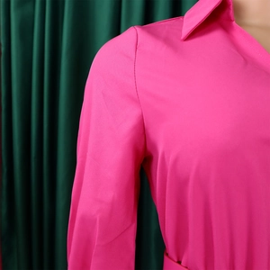 Detail of bright pink long sleeve dress showing lapel collar and shoulder stitching