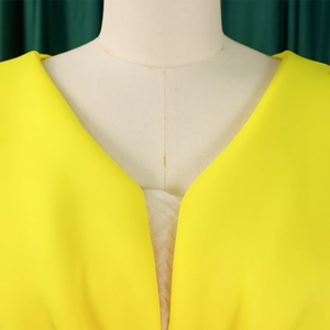 Detailopname van de sexy gele V-hals met ruches en de textuur van een kralen avondjurk