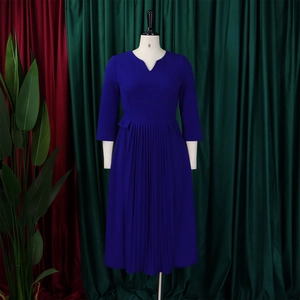 Detail of navy blue V-neck dress featuring pleated skirt and stylish three-quarter sleeves