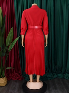 Back view of a long-sleeved red pleated dress with a matching belt on a mannequin