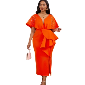 Detail van oranje avondjurk met V-hals, parelversiering en een elegante ruchesplit